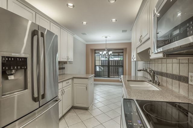 kitchen with light tile patterned flooring, white cabinetry, appliances with stainless steel finishes, an inviting chandelier, and sink