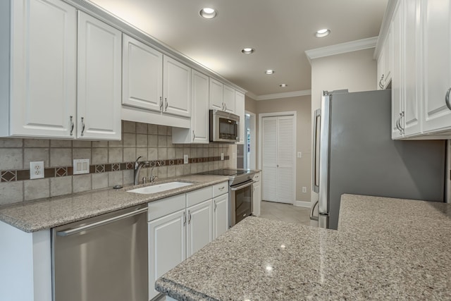 kitchen featuring white cabinetry, appliances with stainless steel finishes, sink, and ornamental molding