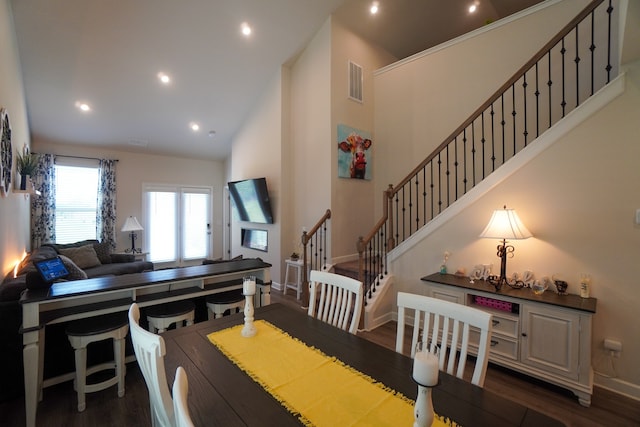 dining space featuring dark hardwood / wood-style flooring and high vaulted ceiling