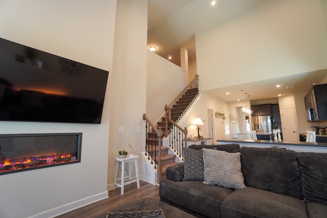 living room with hardwood / wood-style floors and a high ceiling