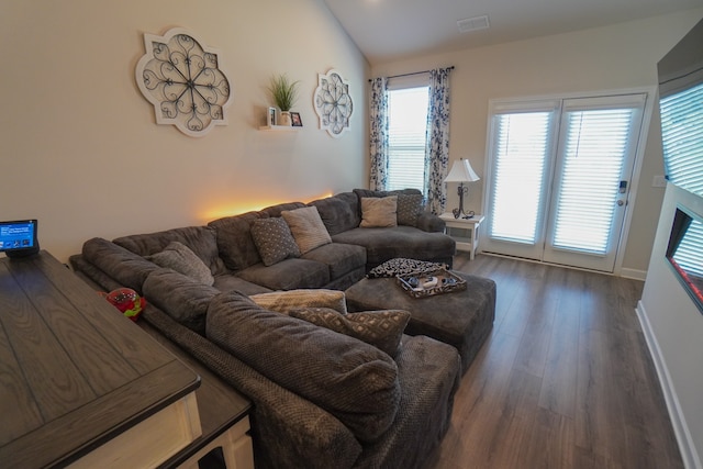 living room featuring dark hardwood / wood-style floors and vaulted ceiling