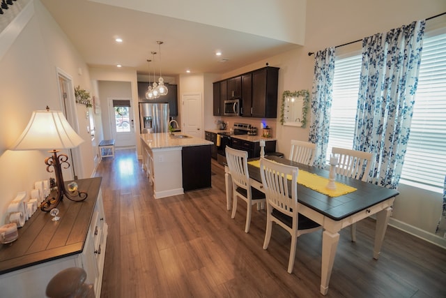 dining room featuring dark wood-type flooring, sink, and an inviting chandelier