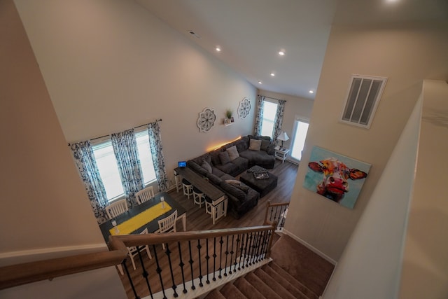 stairs featuring wood-type flooring and a high ceiling