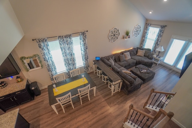 living room featuring high vaulted ceiling and light hardwood / wood-style floors