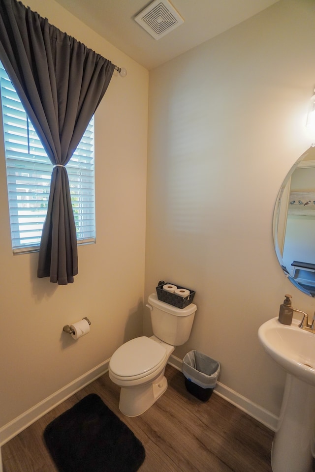 bathroom featuring wood-type flooring, toilet, and sink