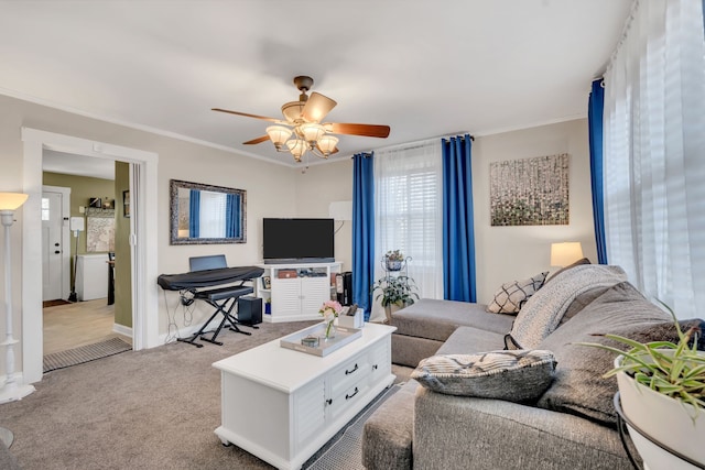 carpeted living room with ornamental molding and ceiling fan