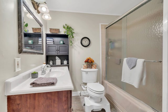 full bathroom featuring toilet, bath / shower combo with glass door, vanity, and ornamental molding