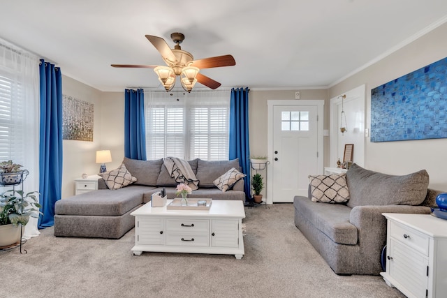 carpeted living room featuring ceiling fan and crown molding