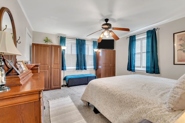 carpeted bedroom with ornamental molding, multiple windows, and ceiling fan