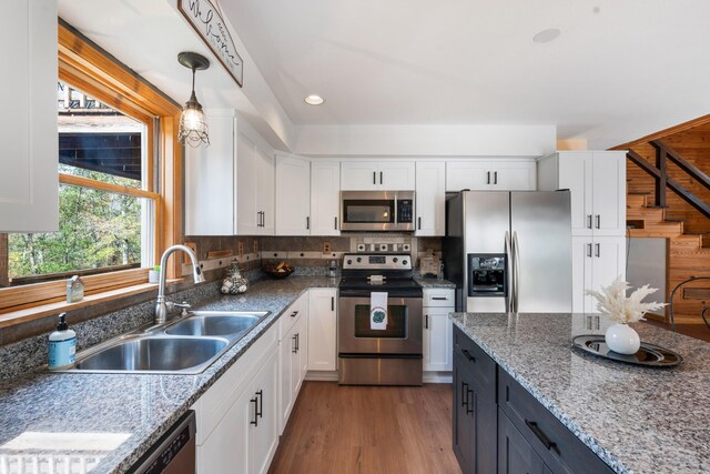 187 Th Hooper Ln, Mc Ewen, TN 37101 - kitchen with appliances with stainless steel finishes, a sink, white cabinetry, pendant lighting, and wood finished floors