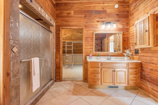 bathroom featuring wood walls, an enclosed shower, vanity, and tile patterned flooring