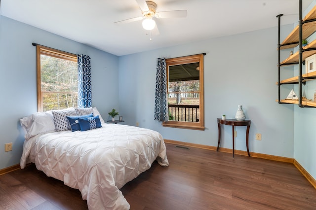 bedroom with ceiling fan, dark hardwood / wood-style floors, and multiple windows