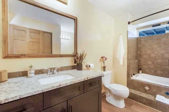 full bathroom with toilet, tiled shower / bath combo, vanity, and wood-type flooring