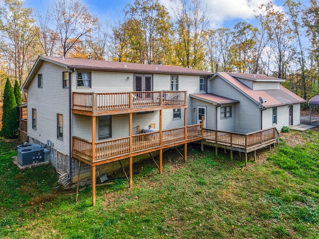 rear view of house featuring a deck, a lawn, and central AC unit