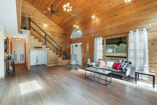 unfurnished living room featuring high vaulted ceiling, wood walls, wood ceiling, hardwood / wood-style flooring, and ceiling fan with notable chandelier