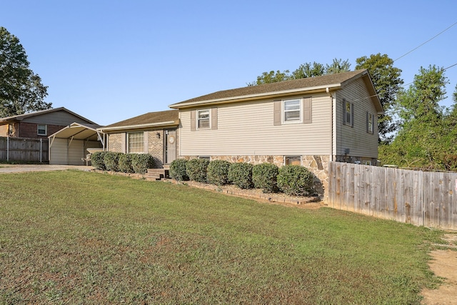 tri-level home with a front lawn and a carport