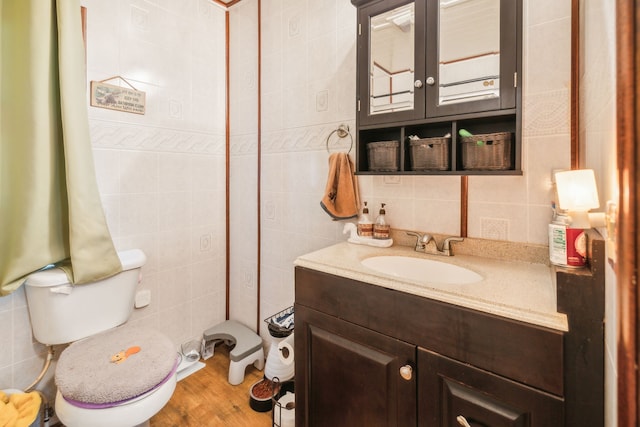 bathroom featuring hardwood / wood-style flooring, vanity, toilet, and tile walls