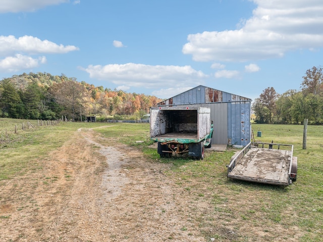 view of outdoor structure with a lawn and a rural view