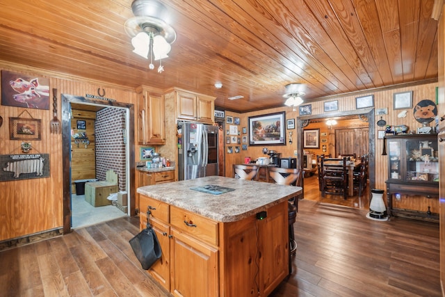 kitchen with stainless steel fridge with ice dispenser, wood walls, wood ceiling, dark wood-type flooring, and a center island