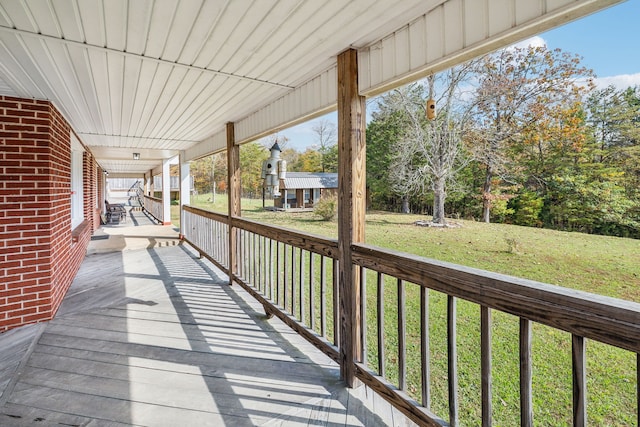 wooden deck featuring a lawn and covered porch