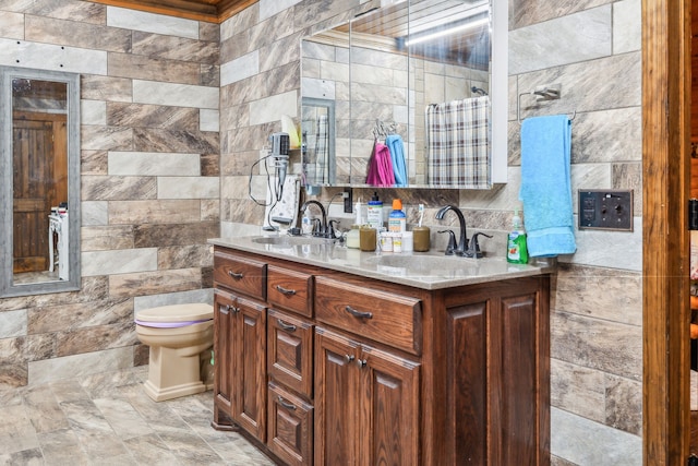 bathroom featuring tile walls, vanity, and toilet