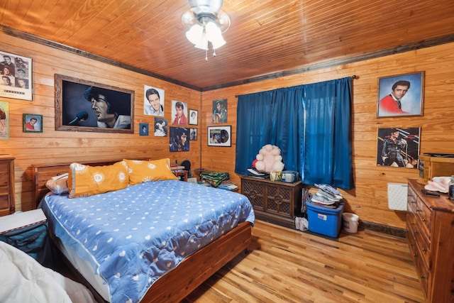 bedroom with hardwood / wood-style floors, wooden ceiling, ceiling fan, and wood walls