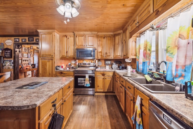 kitchen featuring stainless steel appliances, dark hardwood / wood-style floors, wood walls, sink, and a center island