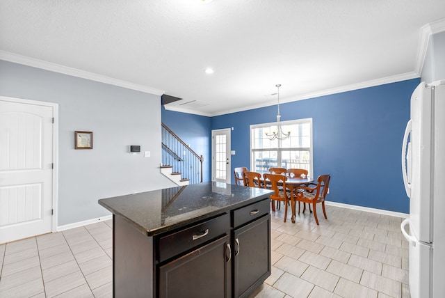 kitchen featuring white refrigerator, crown molding, decorative light fixtures, dark brown cabinets, and a kitchen island