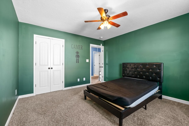 bedroom featuring carpet, a textured ceiling, a closet, and ceiling fan