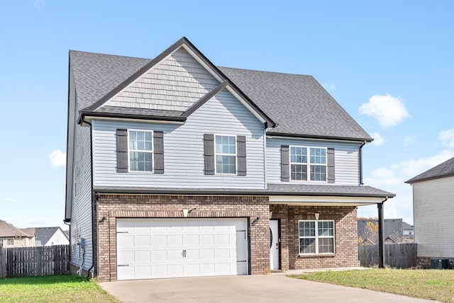 view of front of property featuring cooling unit, a front yard, and a garage