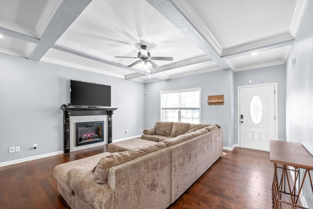 living room with coffered ceiling, ceiling fan, ornamental molding, dark hardwood / wood-style flooring, and a tiled fireplace