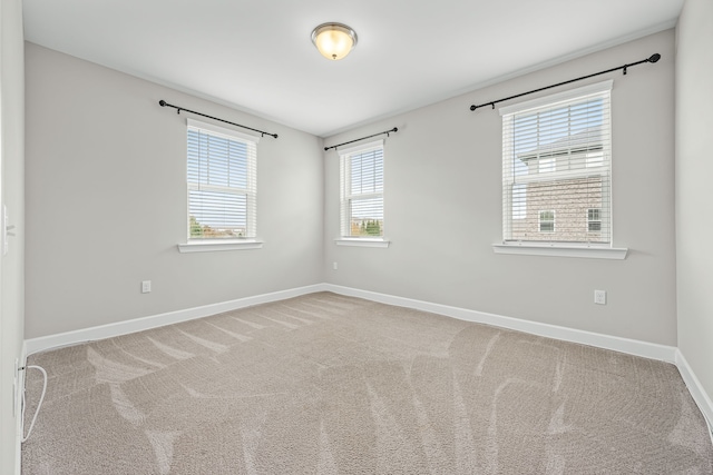 carpeted empty room featuring a wealth of natural light