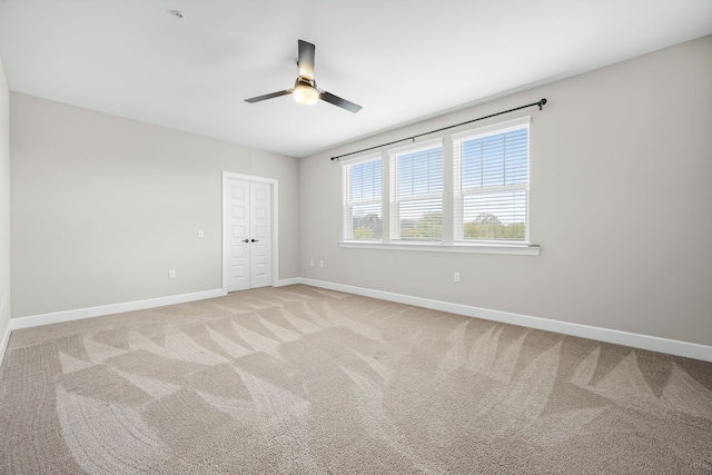 spare room with light carpet and ceiling fan