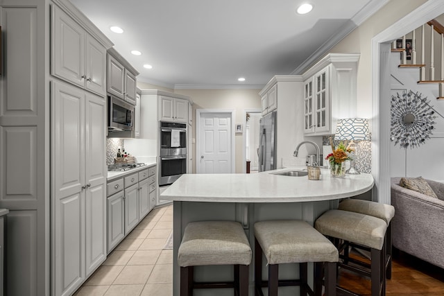 kitchen featuring kitchen peninsula, sink, crown molding, and stainless steel appliances