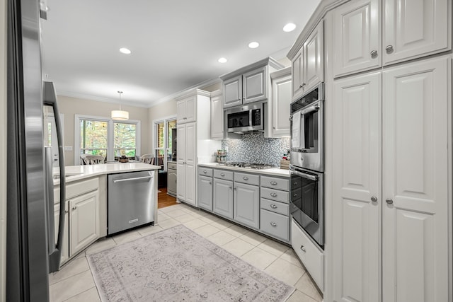 kitchen featuring stainless steel appliances, decorative backsplash, ornamental molding, gray cabinets, and light tile patterned flooring