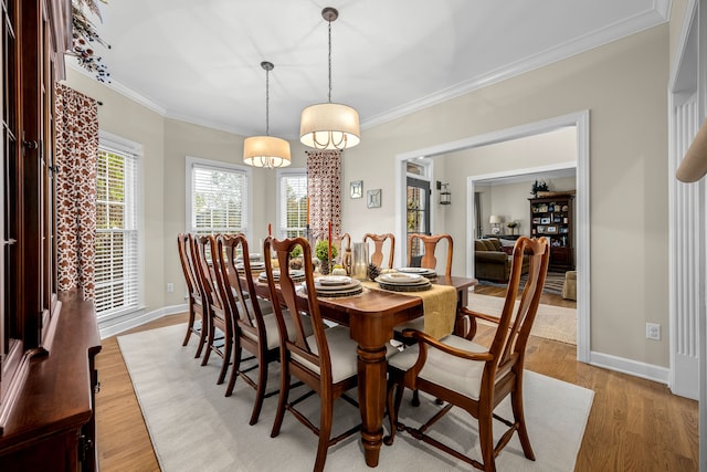 dining space featuring light hardwood / wood-style floors, crown molding, and a notable chandelier