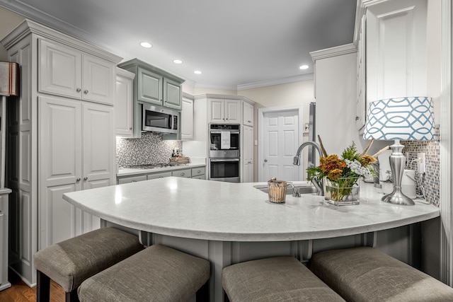 kitchen with kitchen peninsula, sink, crown molding, and stainless steel appliances