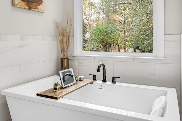 bathroom with tile walls and a washtub