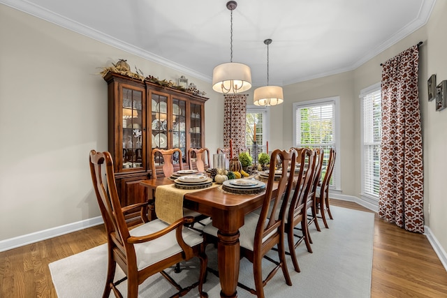 dining area featuring hardwood / wood-style floors, a notable chandelier, and crown molding