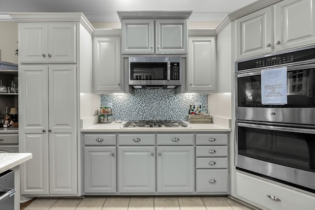 kitchen featuring light tile patterned floors, appliances with stainless steel finishes, and tasteful backsplash