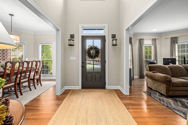 foyer entrance with hardwood / wood-style floors and crown molding