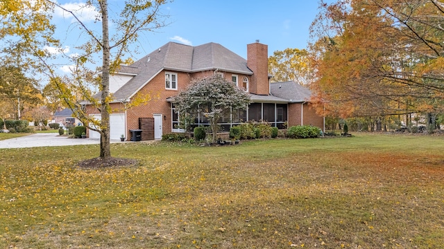 view of front of house with a garage, a front yard, and a sunroom