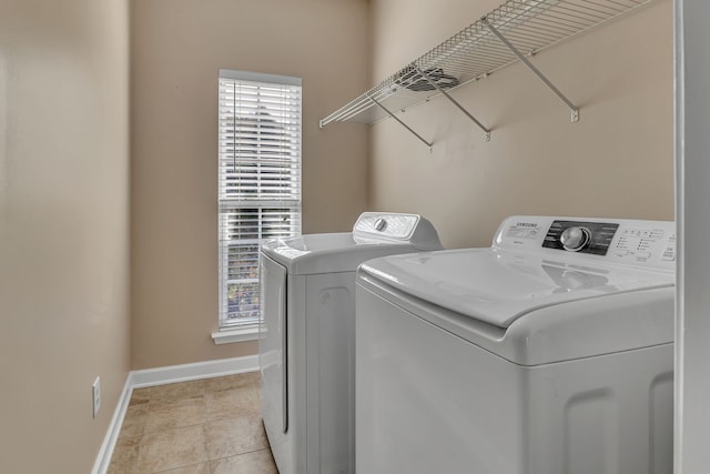 clothes washing area featuring washing machine and dryer, light tile patterned floors, and plenty of natural light