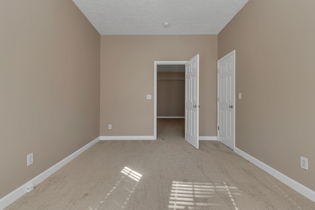 unfurnished bedroom with light colored carpet and a textured ceiling