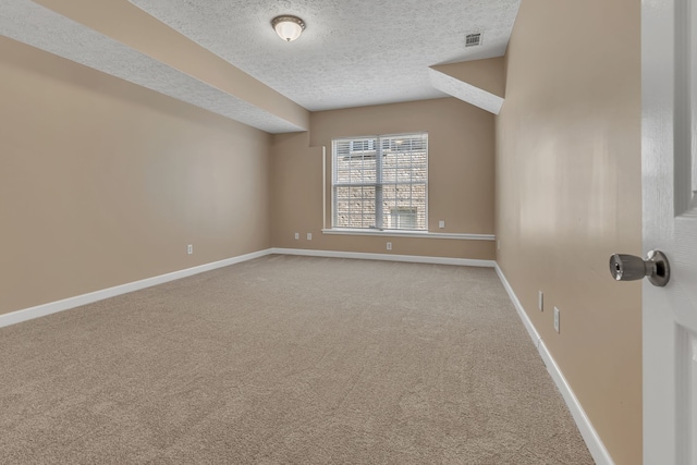 empty room with a textured ceiling and carpet