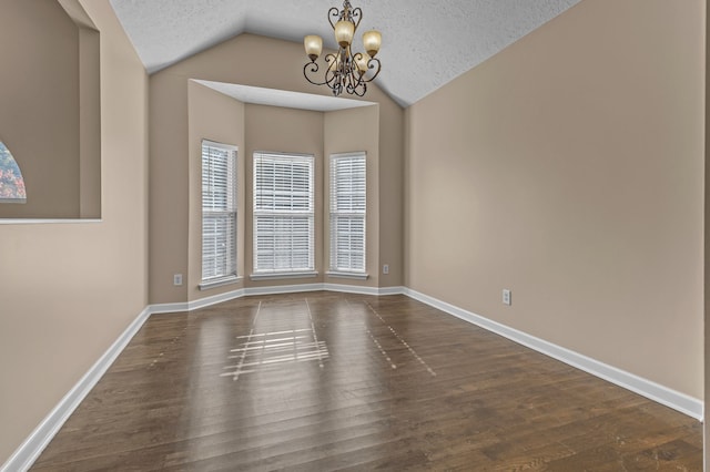 unfurnished room with dark hardwood / wood-style flooring, a textured ceiling, vaulted ceiling, and an inviting chandelier