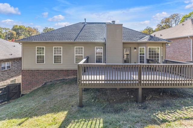 rear view of property featuring a lawn and a wooden deck