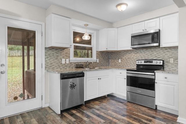 kitchen with dark wood-type flooring, white cabinets, decorative light fixtures, and stainless steel appliances