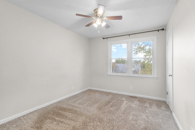 carpeted spare room with a textured ceiling and ceiling fan