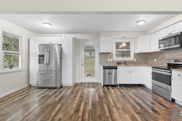 kitchen with white cabinetry, appliances with stainless steel finishes, dark wood-type flooring, and tasteful backsplash